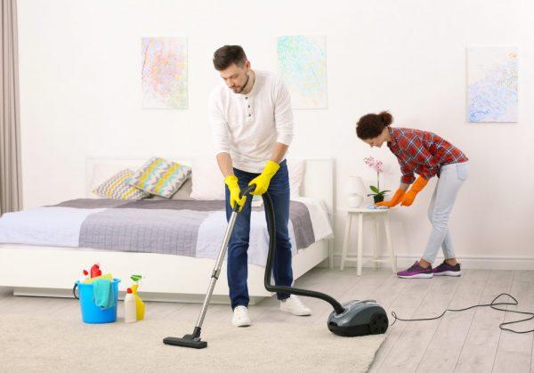 Семейная пара делает уборку в квартире